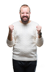 Fototapeta premium Young caucasian hipster man wearing winter sweater over isolated background excited for success with arms raised celebrating victory smiling. Winner concept.