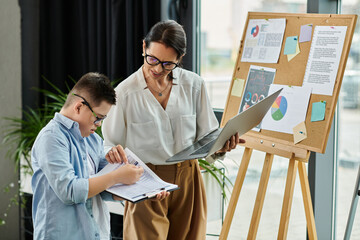 A mother and her son with Down syndrome work together in an office, showcasing inclusion and diversity.