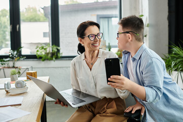 A mother and her son with Down syndrome work together in a modern office, demonstrating inclusion...