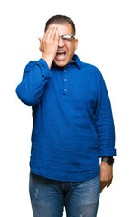 Fototapeta premium Middle age arab man wearing glasses over isolated background covering one eye with hand with confident smile on face and surprise emotion.