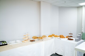 The room features a buffet table filled with a variety of food items, likely set up for an event. The decor includes wooden flooring, a rectangular table, and a ceiling above