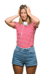 Young beautiful woman listening music wearing headphones over isolated background suffering from headache desperate and stressed because pain and migraine. Hands on head.