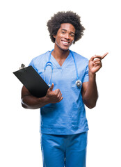 Afro american surgeon doctor holding clipboard man over isolated background very happy pointing with hand and finger to the side