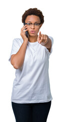 Young african american woman talking on the phone over isolated background pointing with finger to the camera and to you, hand sign, positive and confident gesture from the front