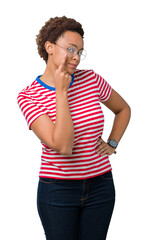 Beautiful young african american woman wearing glasses over isolated background Pointing to the eye watching you gesture, suspicious expression