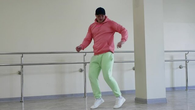Dance fast steps, creative dance of a young guy quickstep in the studio. Dance with legs up