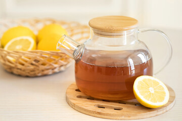 Tea with slice of lemon and honey on wooden table and blue background