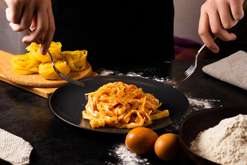 Hand uses chopsticks to pickup tasty noodles. Asian meal on a table, junk food concept