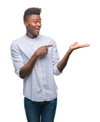 Young african american man over isolated background amazed and smiling to the camera while presenting with hand and pointing with finger.