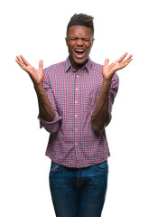 Fototapeta premium Young african american man over isolated background celebrating mad and crazy for success with arms raised and closed eyes screaming excited. Winner concept
