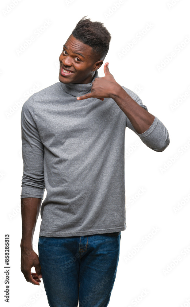 Wall mural young african american man over isolated background smiling doing phone gesture with hand and finger