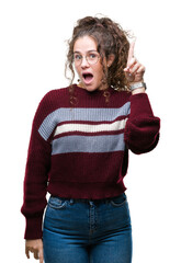 Beautiful brunette curly hair young girl wearing glasses over isolated background pointing finger up with successful idea. Exited and happy. Number one.