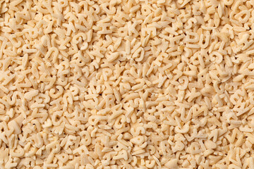 Uncooked alphabets pasta full frame close up as background