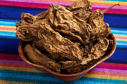 Bowl with Mexican Chile Chipotle Meco close up on a colorful cloth  