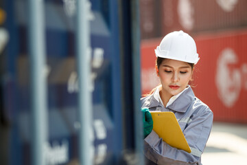 Female ship yard staff inspects the cargo containers at ship yard.