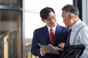 Asian businesspeople talking or discussing at the modern building hallway.