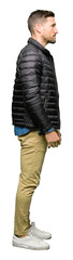 Handsome man wearing winter coat looking to side, relax profile pose with natural face with confident smile.