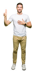 Handsome man wearing casual white t-shirt Swearing with hand on chest and fingers, making a loyalty...