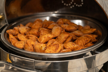Mini vegan Empanadas at an event in a metal warmer. Very spicy and crunchy food.