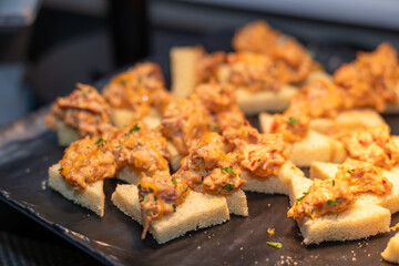 Chicken bread bite appetizer. Shredded spicy chicken on crunch bread triangles