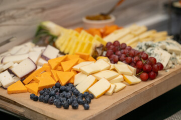 Cheese board at an event with variety of fruit and cheese. Cheese plate at a get together