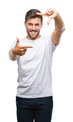 Fototapeta premium Young handsome man over isolated background smiling making frame with hands and fingers with happy face. Creativity and photography concept.
