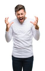 Fototapeta premium Young handsome man over isolated background celebrating mad and crazy for success with arms raised and closed eyes screaming excited. Winner concept