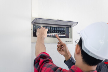 Resetting tripped breaker in residential electricity power control panel in homes and buildings. Men electrician turning off power for electrical outlet at circuit breaker box.