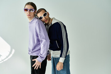 Two stylish men standing together wearing sunglasses.