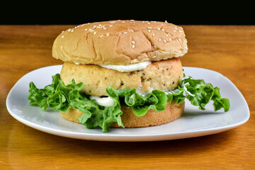 salmon burger top with  tarter sauce and parsley
