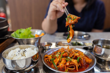 woman use chopstick eating Korean cuisine, Kimchi pork stir-fry with vegetables served with a side of steamed white rice topped with black sesame seeds