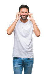 Adult hispanic man over isolated background covering ears with fingers with annoyed expression for...
