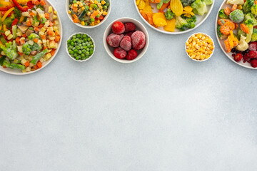 Preparing fresh vegetables in summer for winter, various frozen vegetables and berries in plates on...