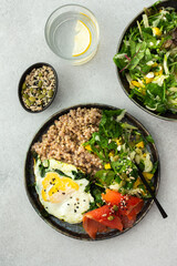 Delicious healthy breakfasts, green buckwheat with fried egg and spinach and red salmon fish, mix salad with fresh herbs and peppers and seeds, healthy balanced breakfast with fats, fiber and protein