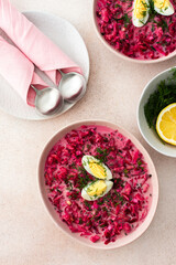 Summer cold beetroot soup made from beets, radishes, cucumbers, potatoes and herbs, garnished with egg, a refreshing summer lunch