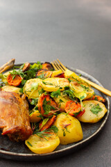 A hearty delicious dinner, baked rabbit with potatoes and carrots, a set table with food