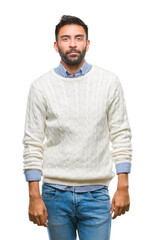 Fototapeta premium Adult hispanic man wearing winter sweater over isolated background with serious expression on face. Simple and natural looking at the camera.