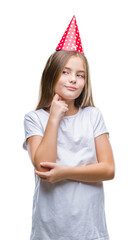 Young beautiful girl wearing birthday cap over isolated background with hand on chin thinking about question, pensive expression. Smiling with thoughtful face. Doubt concept.