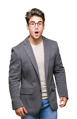 Fototapeta premium Young business man wearing glasses over isolated background afraid and shocked with surprise expression, fear and excited face.