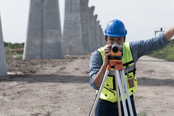surveyor at work. construction worker using level camera. Surveyor with  looking throughout digital...