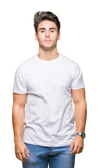 Young handsome man wearing white t-shirt over isolated background Relaxed with serious expression on face. Simple and natural looking at the camera.