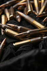 Naklejka premium Cartridges for automatic carbine caliber .223 on charcoal. Ammunition for automatic and semi-automatic rifles. Dark back
