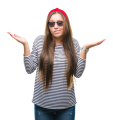 Young beautiful caucasian woman wearing sunglasses over isolated background clueless and confused...