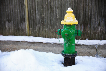 fire hydrant stands out against a serene blanket of snow in a quiet winter landscape, symbolizing...