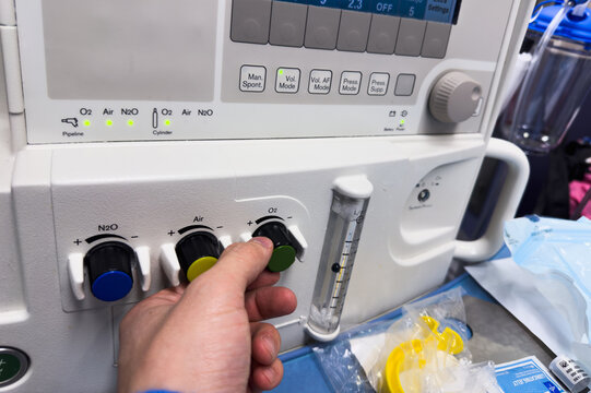 modern hospital anesthesia machine with airway ventilation system, featuring digital screens and various tubes, set in a clean and well-lit surgical room, ready for patient care
