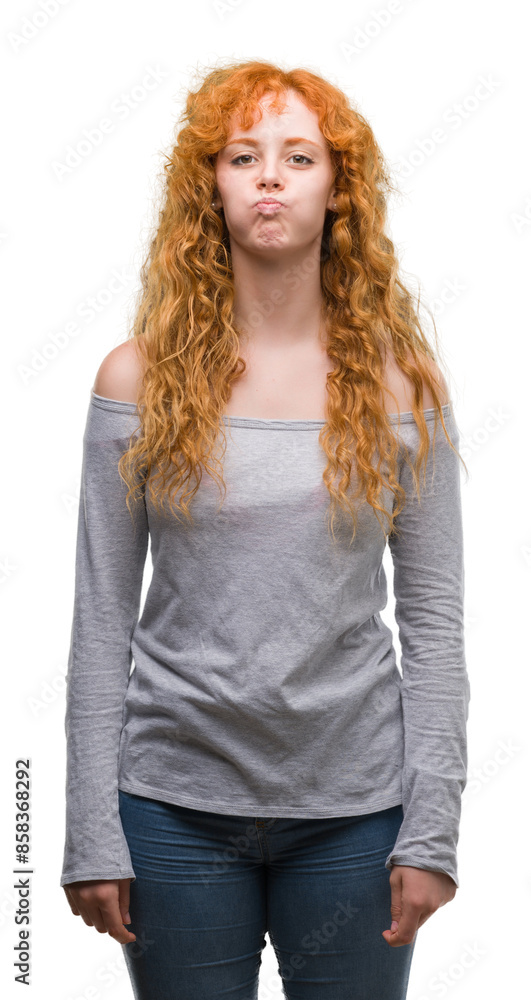 Poster Young redhead woman puffing cheeks with funny face. Mouth inflated with air, crazy expression.