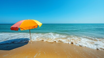 A serene beach scene featuring gentle waves lapping against the shore and a colorful beach umbrella providing shade