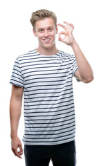 Young handsome blond man wearing stripes sailor t-shirt doing ok sign with fingers, excellent symbol
