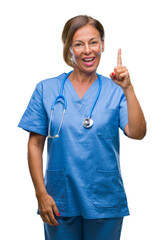 Middle age senior nurse doctor woman over isolated background pointing finger up with successful idea. Exited and happy. Number one.