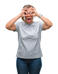 Middle age senior hispanic woman wearing glasses over isolated background doing ok gesture like binoculars sticking tongue out, eyes looking through fingers. Crazy expression.